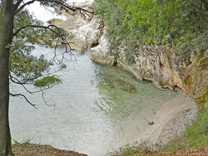 Un paysage naturel caractérisé par une étendue d’eau claire, entourée de reliefs rocheux et de végétation.