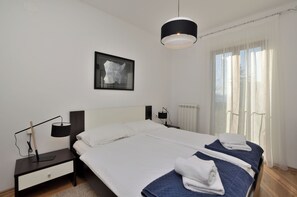 A bedroom with a bed, bedside tables, a lamp, a picture on the wall, and a window with curtains. - Apartment Maria (Labin)