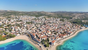 Vue aérienne d’une ville côtière, avec ses bâtiments, sa plage et ses eaux bleues et limpides.