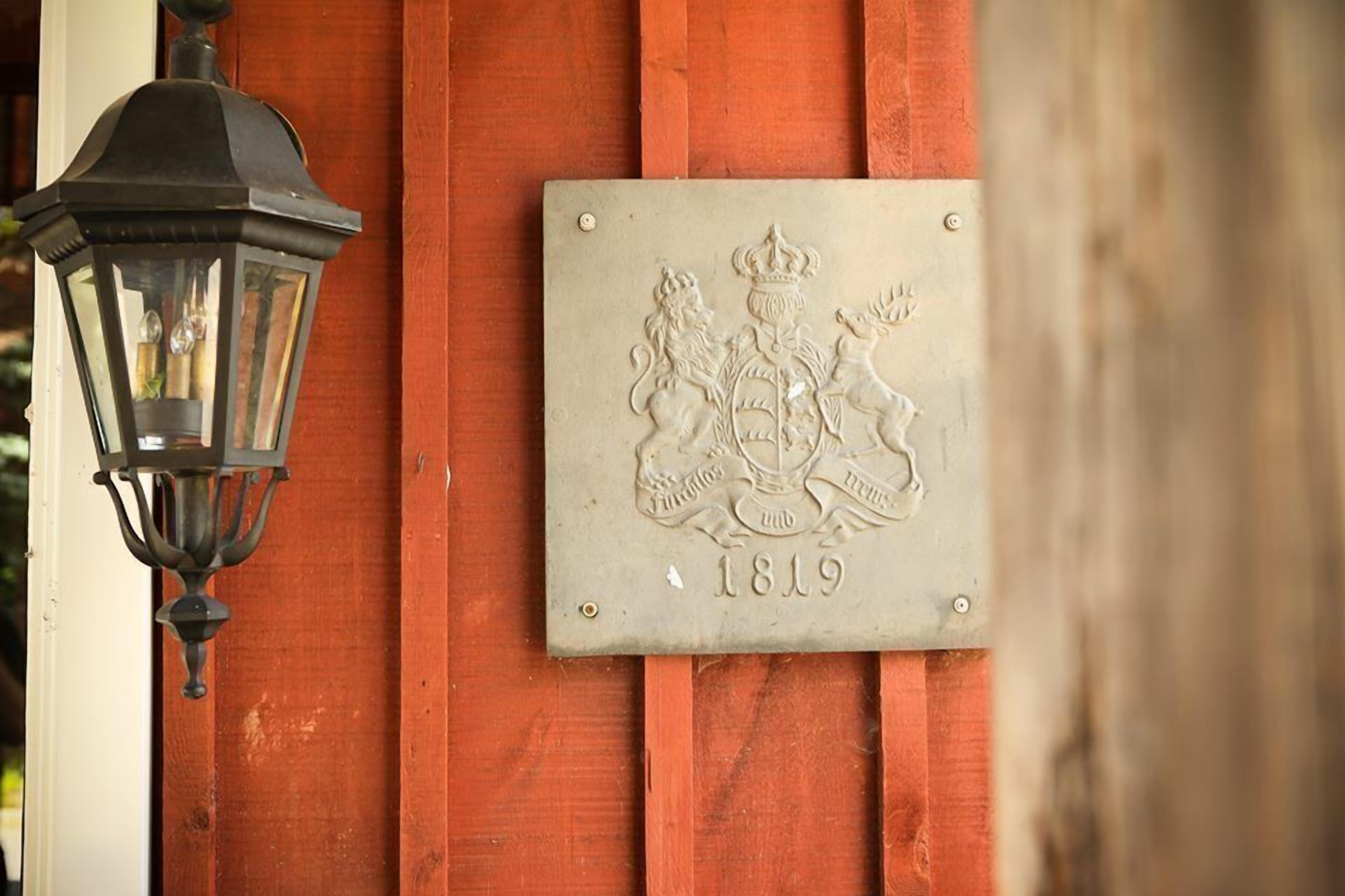 Una placa amb un escut i la data 1819 a una paret de fusta.