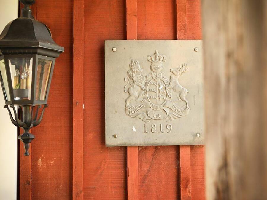 Una placa amb un escut i la data 1819 a una paret de fusta.