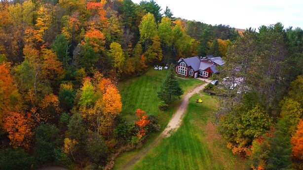 A house surrounded by a forest with a lawn and a path leading to it. - Trillium Resort & Spa (Huntsville)