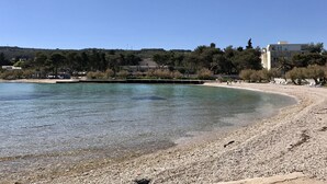 A beach with clear water, pebbles, and a few people. - House Andelka (Supetar)