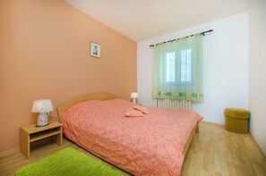 A bedroom with a bed, nightstand, lamp, and a small stool. - House Andelka (Supetar)