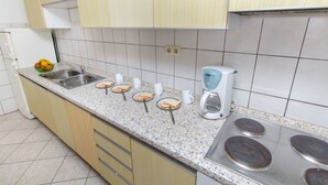A kitchen with a granite countertop, stainless steel sink, and a coffee maker. - Apartment Neda (Duce)