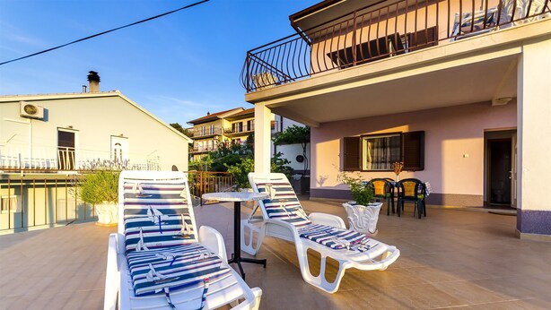 A rooftop terrace with sun loungers, a table, and chairs. - Apartment Marijana (Trogir)