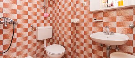 A bathroom with a checkered tile pattern, a toilet, a sink, and a bathtub.