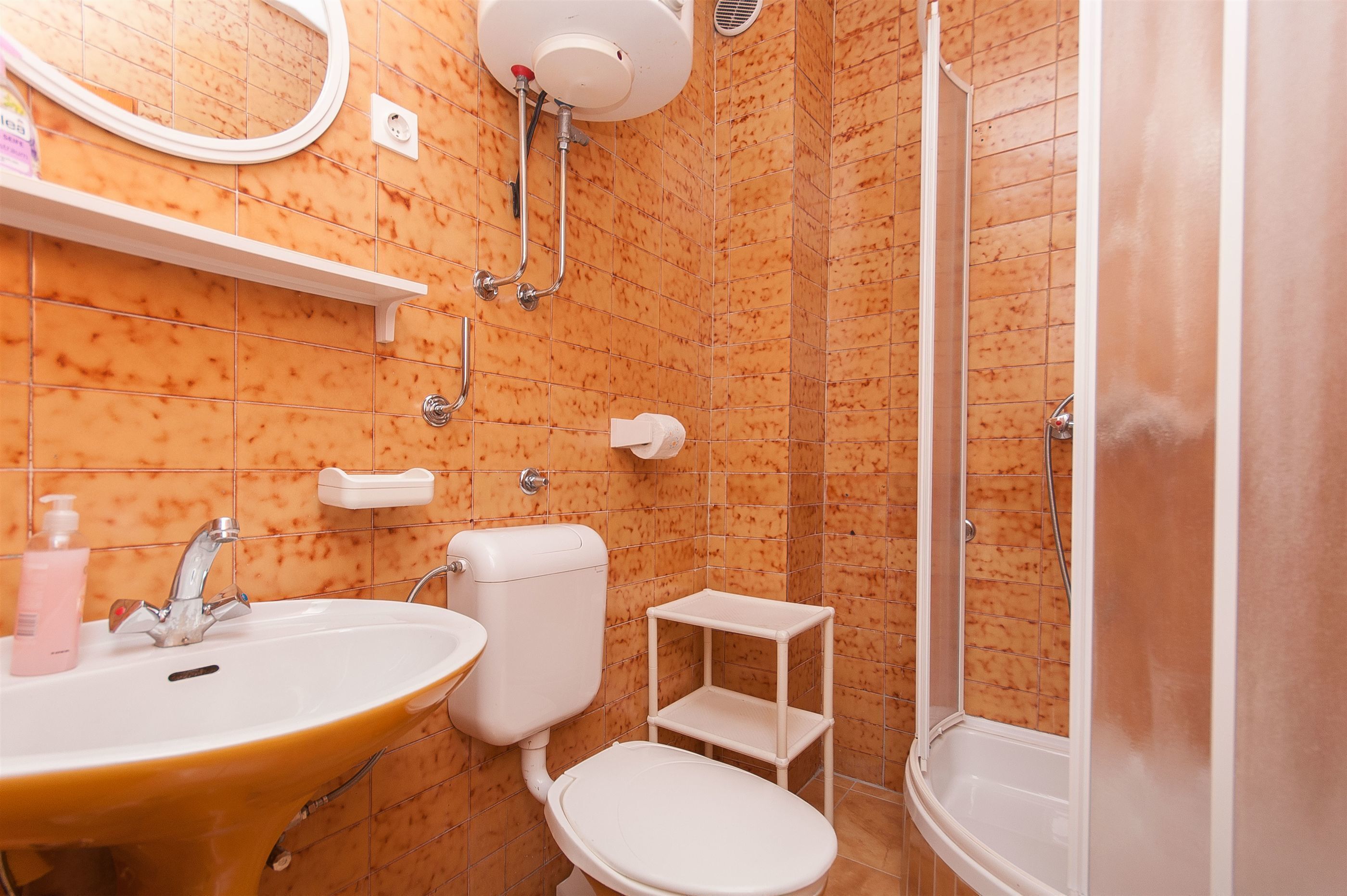 A bathroom with a sink, toilet, and shower.