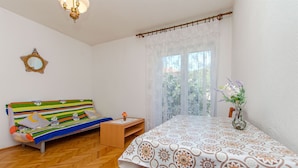 A room with a bed, a small table, a mirror, and a window with a view. - Apartments Bozjidar (Stari Grad)