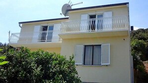 Un immeuble de deux étages doté de balcons et d  ’une antenne parabolique.