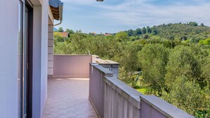A balcony with a view of a green hillside and a clear sky. - Apartment Leo (Racisce)