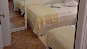 Une chambre avec deux lits, un miroir et une table de chevet.