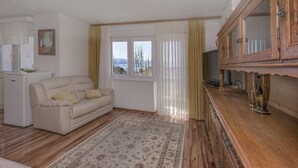 A living room with a sofa, a television, and a cabinet. - Apartment Nansy (Omis)