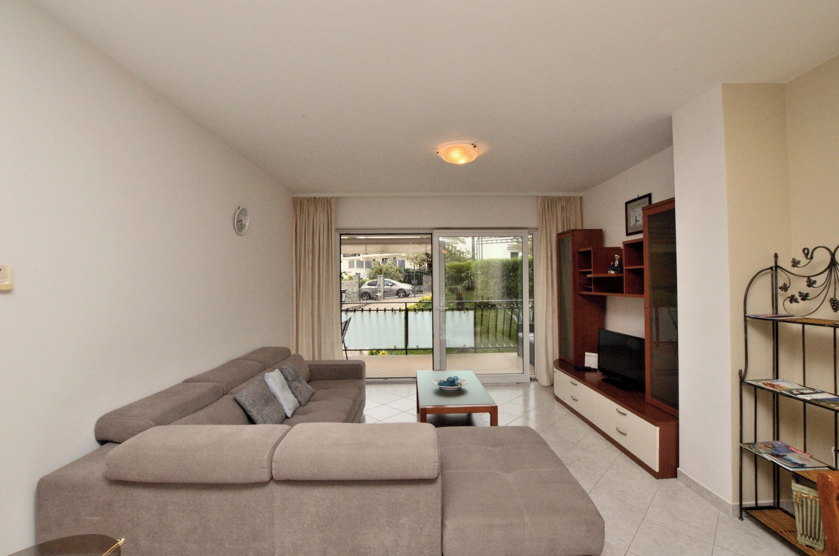 A living room with a sofa, a coffee table, a TV stand, and a bookshelf.