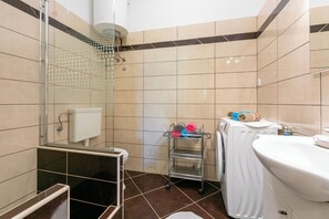 A bathroom with a shower, toilet, and sink. - Apartment Milojka (Crikvenica)