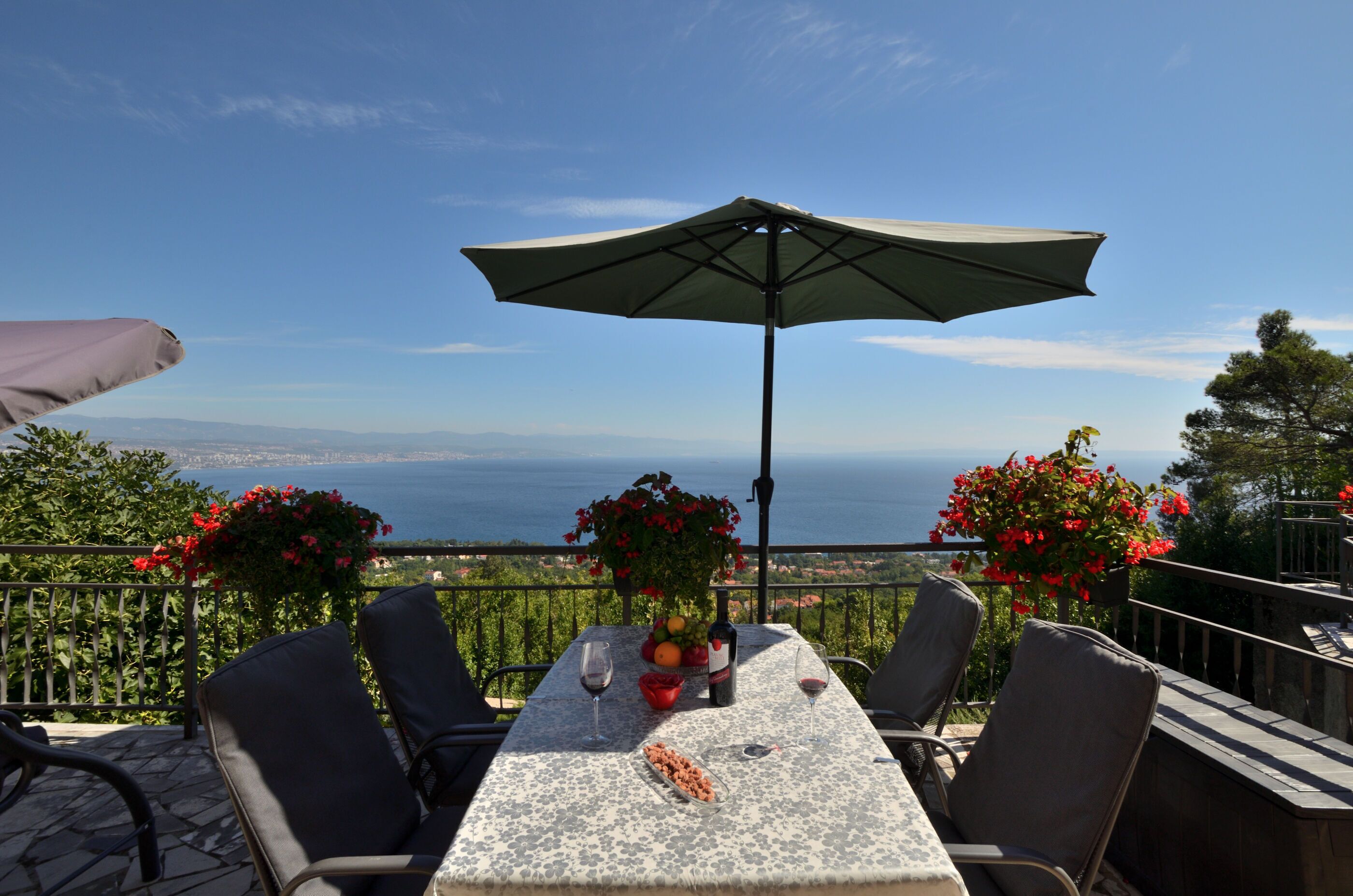 A table with chairs and an umbrella, overlooking a scenic view.