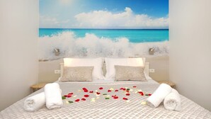 A bedroom with a bed, pillows, and a wall mural of a beach scene. - Apartments Redstone Luxury Apartments (Sveta Nedjelja)