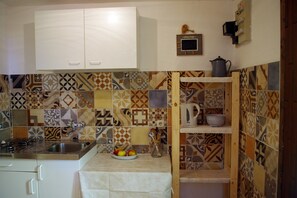 Privékeuken | Een koelkast, een kookplaat, kookgerei, borden en bestek, een vriezer