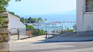 Une vue sur la côte, avec un bâtiment blanc, une clôture en métal et un ciel bleu dégagé.