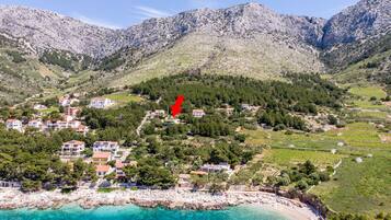 Un pueblo costero con casas, viñedos y un litoral rocoso.