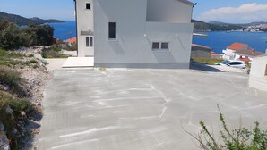 A modern two-story house with a flat roof and a large driveway. - Apartments Brulo (Razanj)