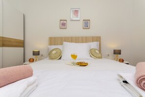 A hotel room with a bed, pillows, a bedside table with a lamp, and a framed quote on the wall. - Apartments and Room Gabriels Paradise (Kastel Luksic)