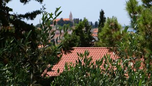 Ein Gebäude mit rotem Ziegeldach, umgeben von Grünflächen und Bäumen.