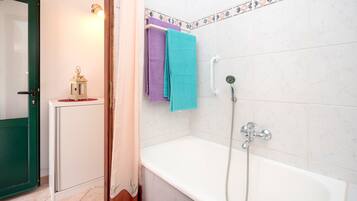 Une salle de bain avec une baignoire, une douche et des toilettes.