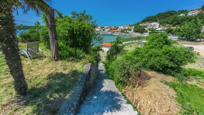 Un sendero que lleva a una zona costera con casas y vegetación.