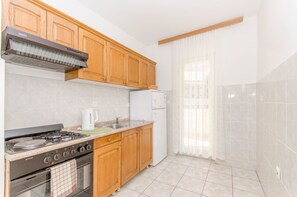 Private kitchen | Fridge, oven, stovetop, electric kettle - Apartments and Room Sun and Sea (Podgora)