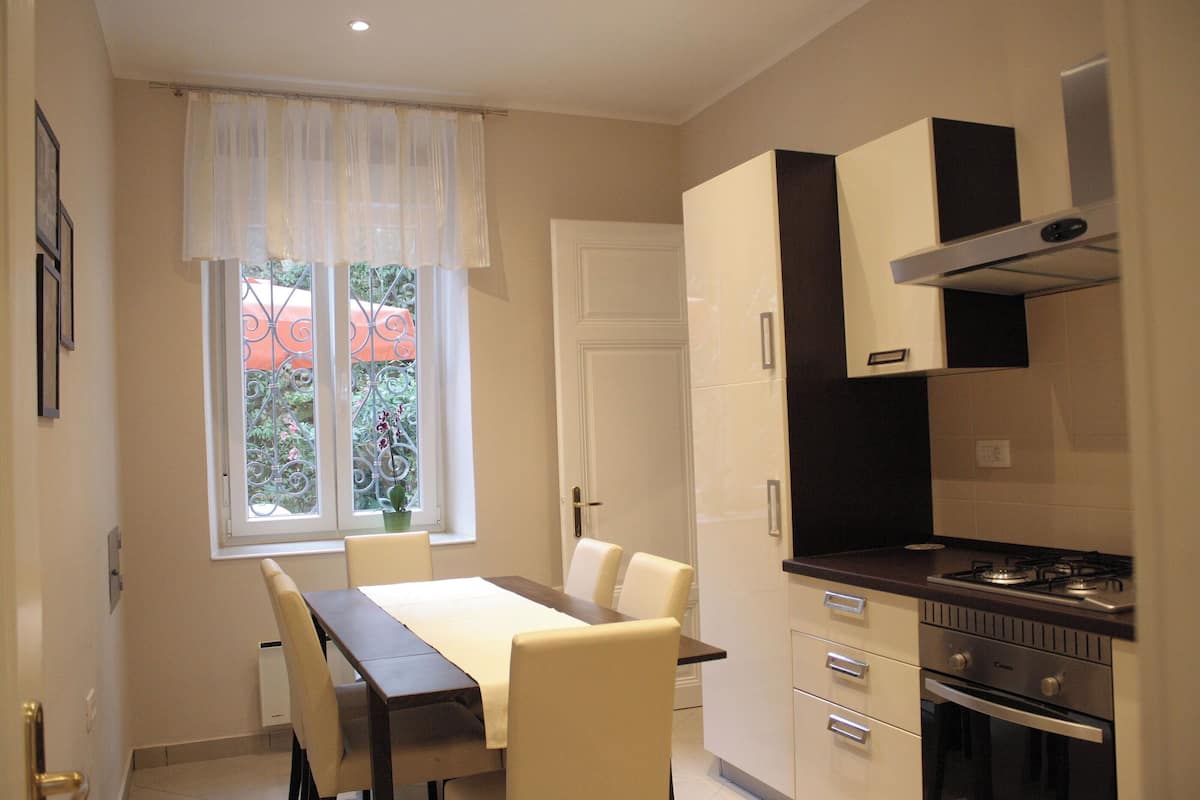 A compact kitchen with a dining area, featuring a stove, oven, and cabinets.