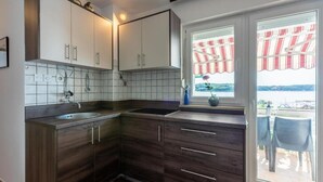 Keittiössä on pesuallas, kaappeja ja ikkuna, josta avautuu näkymä parvekkeelle ja sieltä merelle.