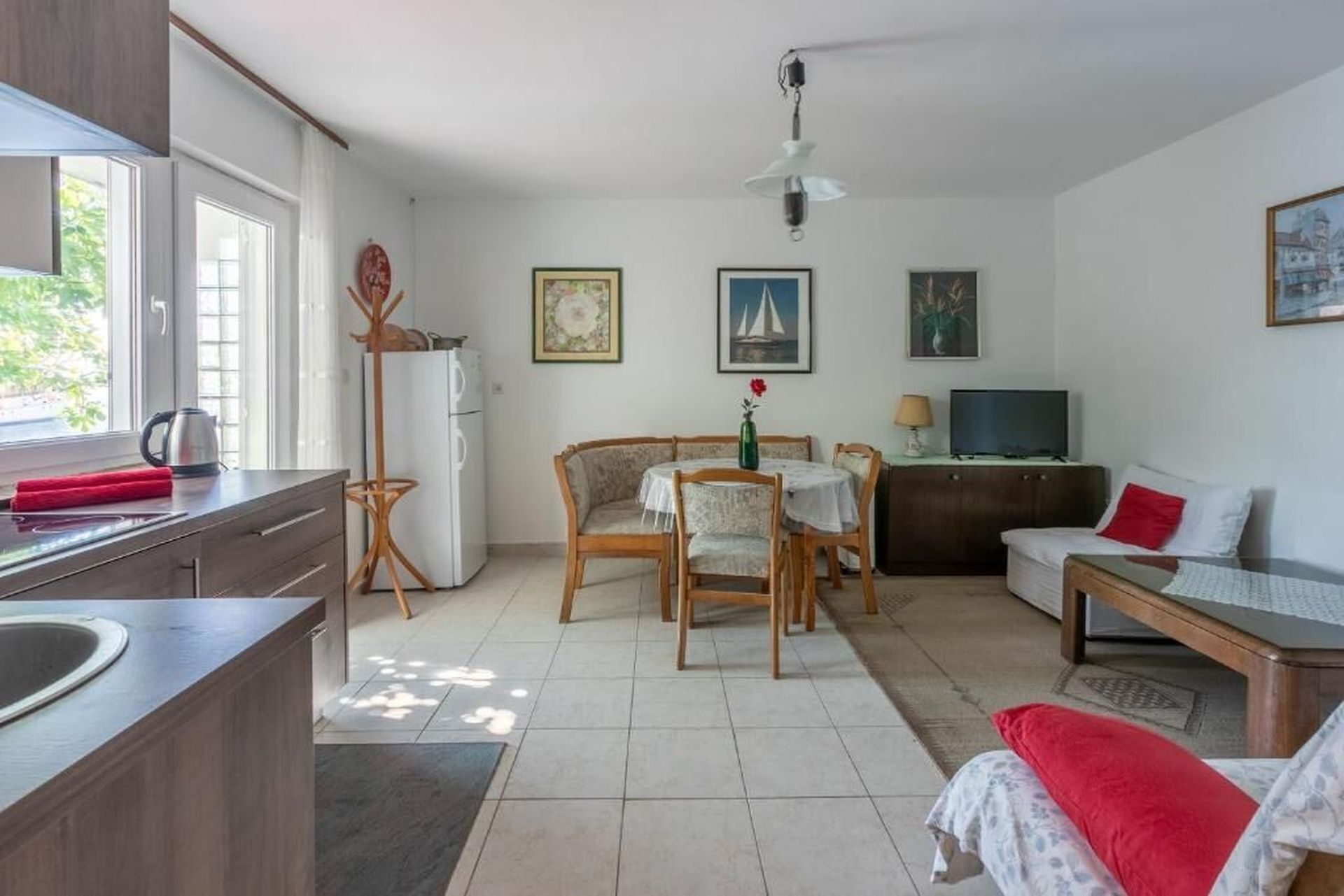 Un espacio habitable compacto con kitchenette, comedor y zona de estar.