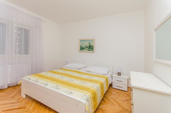 A bedroom with a bed, bedside table, and a desk. - Apartment Sime (Brodarica)