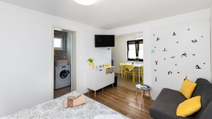 Ein modernes Apartment mit Wohnzimmer, Essbereich und Küche.