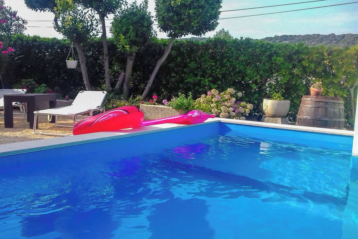 A swimming pool with lounge chairs and a red inflatable float.