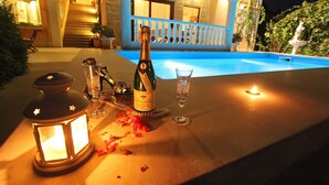 A table with a bottle of champagne, two glasses, a candle, and a lantern. - Apartments Barbara (Lovran)