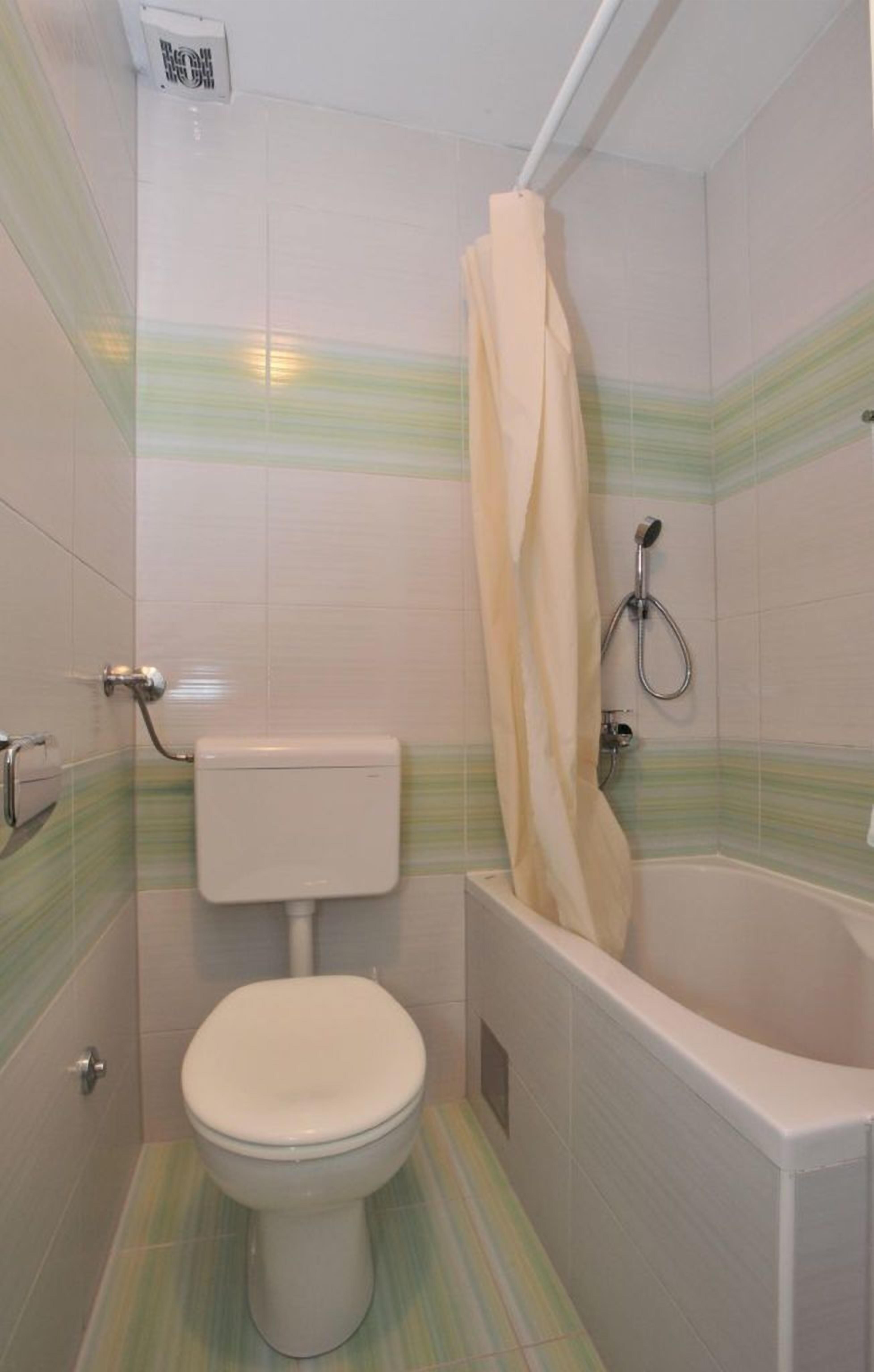 A small bathroom with a toilet, a shower, and a bathtub.