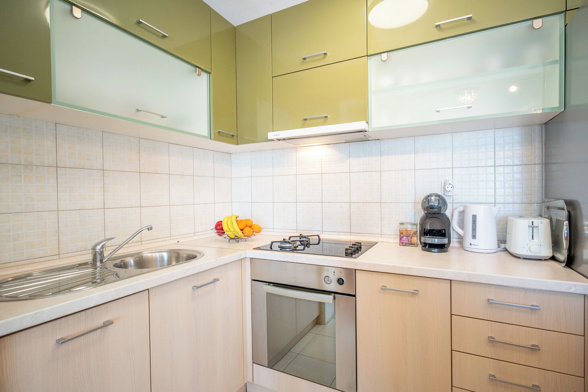 A kitchen with a sink, stove, oven, and various appliances.