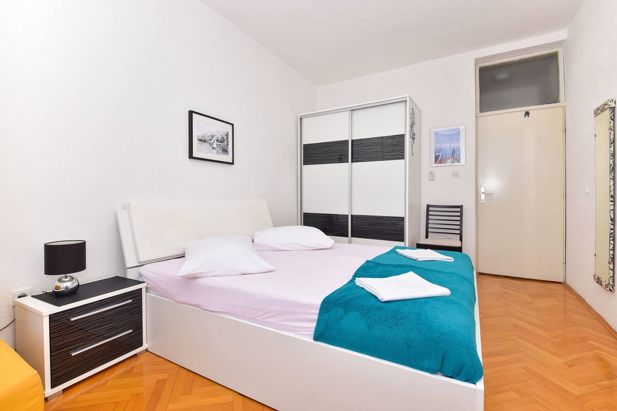 Une chambre à coucher moderne, avec un lit, une table de chevet, une armoire et une porte.