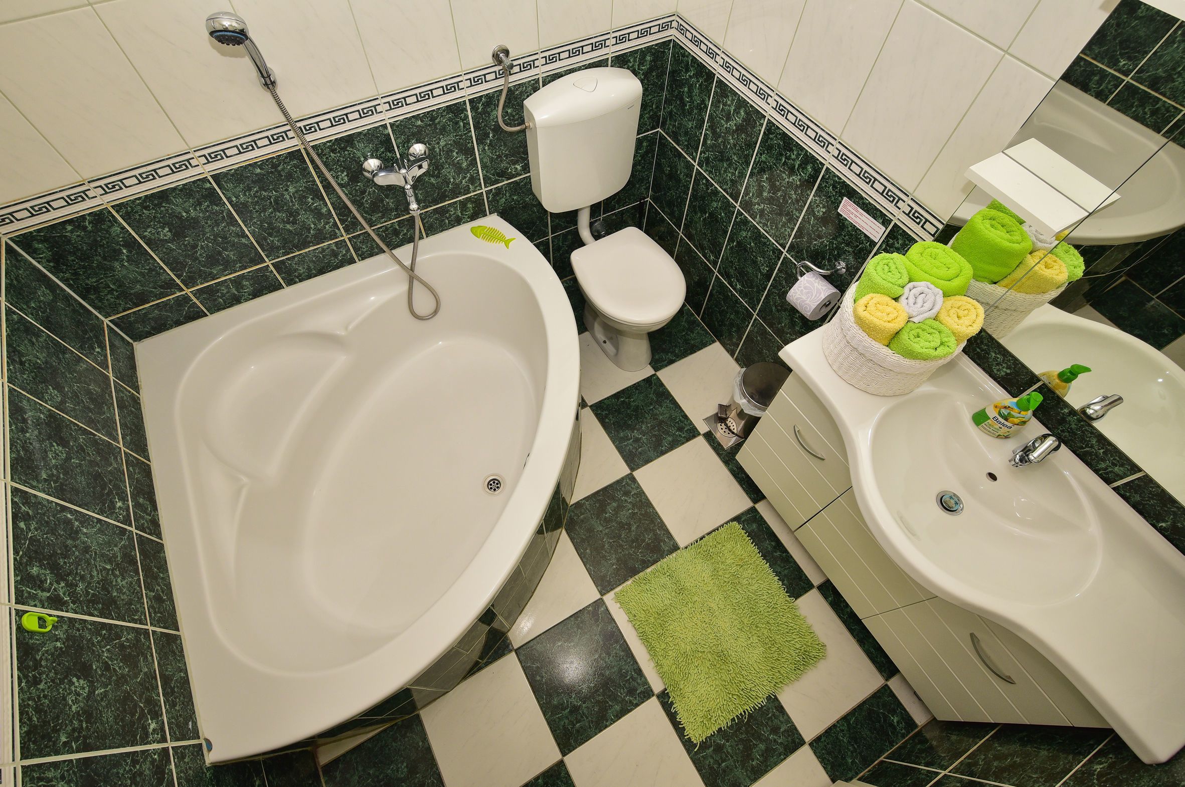 Een badkamer met een groot bad, een toilet en twee wasbakken.