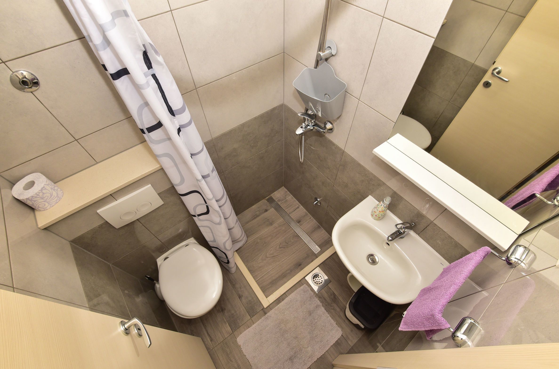 Un bagno moderno con toilette, bidet, lavandino e doccia.