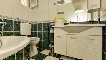 A bathroom with a white sink, toilet, and vanity with drawers.