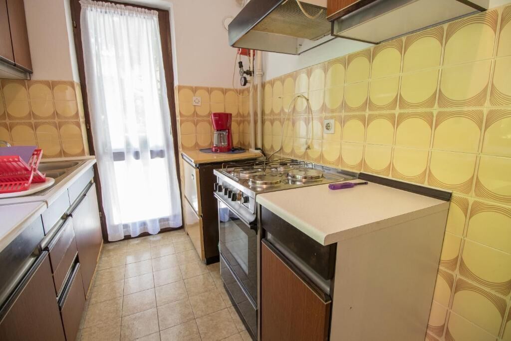 A compact kitchen with a gas stove, oven, and a coffee maker on the countertop.