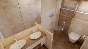 Un baño moderno con dos lavabos, ducha e inodoro.