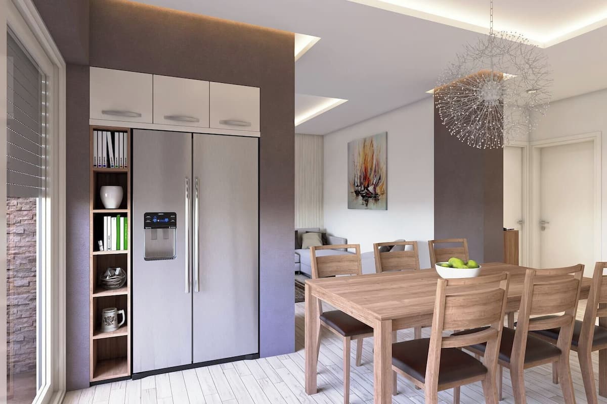 A modern kitchen with a built-in refrigerator, a dining table with chairs, and a hanging light fixture.