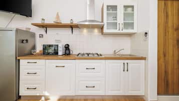 Apartamento (A1) | Cozinha privada | Geladeira, cooktop, talheres/pratos/utensílios de cozinha