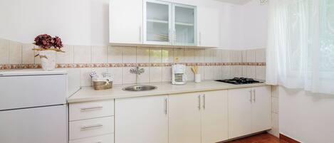 Appartement (A3) | Privékeuken | Een koelkast, een kookplaat, kookgerei, borden en bestek