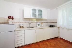 Apartamento (A3) | Cozinha privada | Geladeira, cooktop, talheres/pratos/utensílios de cozinha