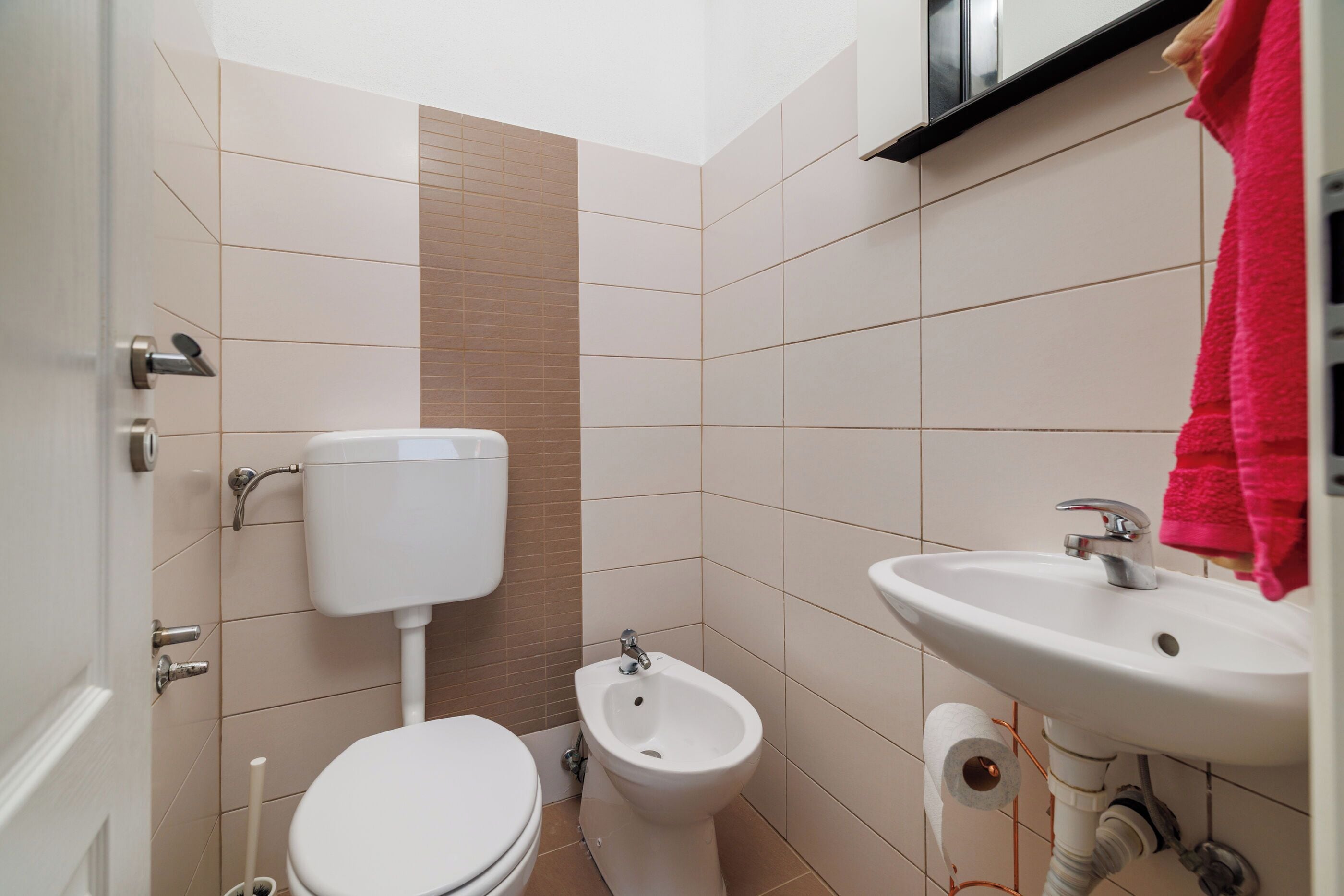 A bathroom with a toilet, bidet, and sink.